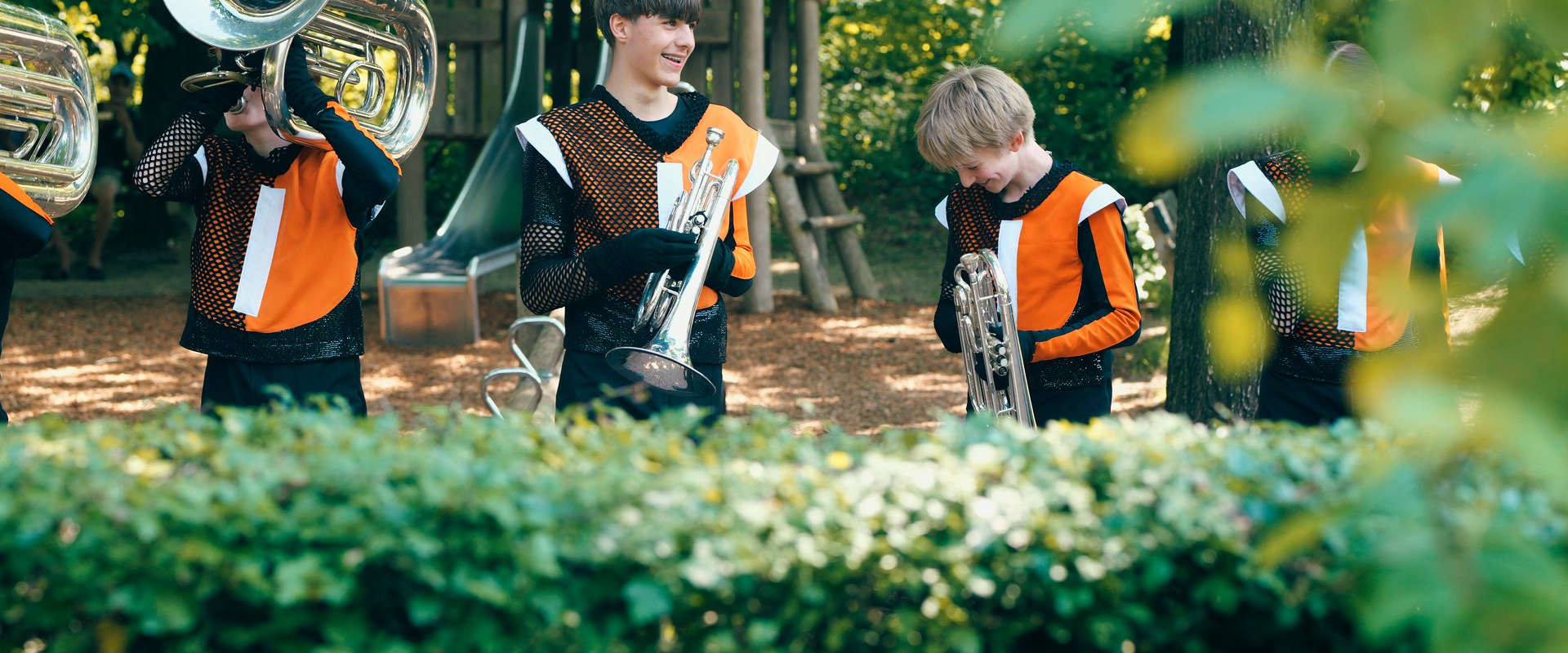 Jonge Juballers met tuba, trompet en bariton tijdens een optreden in het park